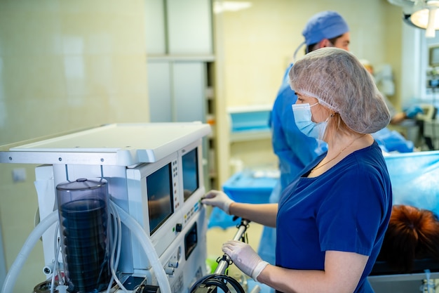 Portrait de jeune infirmière chirurgicale en gommages debout en salle d'opération. Portrait de femme médecin dans une salle médicale moderne.