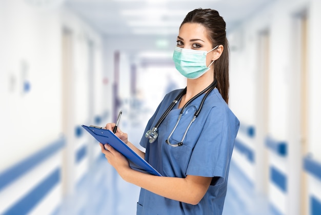 Portrait d'une jeune infirmière masquée dans un hôpital