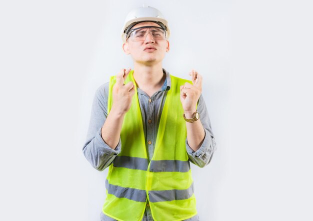 Photo portrait d'un jeune ingénieur faisant un vœu un beau ingénieur croisant les doigts en faisant un voeu