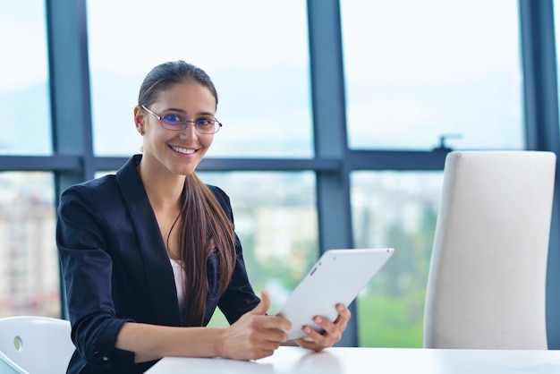 portrait de jeune jolie femme d'affaires travaillant sur un ordinateur portable dans le bureau moderne et lumineux à l'intérieur