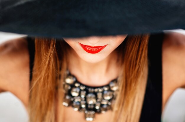 Portrait de jeune jolie femme au chapeau noir