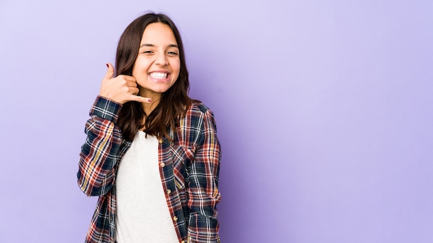 Portrait d'une jeune jolie femme montrant le geste du téléphone mobile