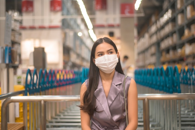 Portrait de jeune jolie femme portant un masque chirurgical dans un centre commercial, covid-19 et concept pandémique