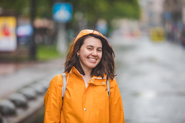 Portrait de jeune jolie femme souriante en imperméable avec capuche