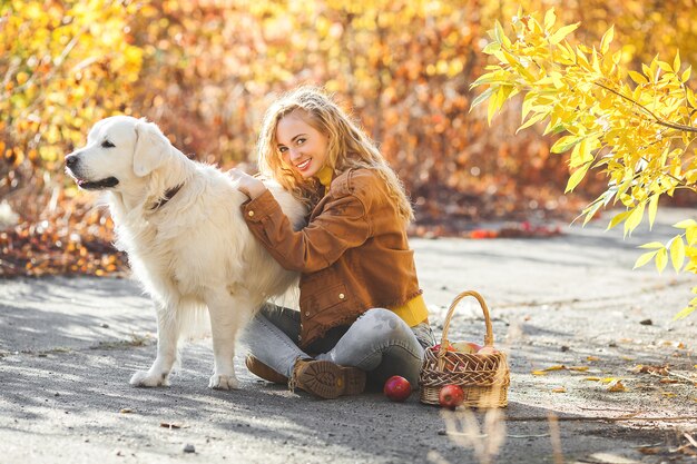 Portrait de jeune jolie fille blonde avec chien. Propriétaire d'animal domestique. Golden retriever et son propriétaire en automne.