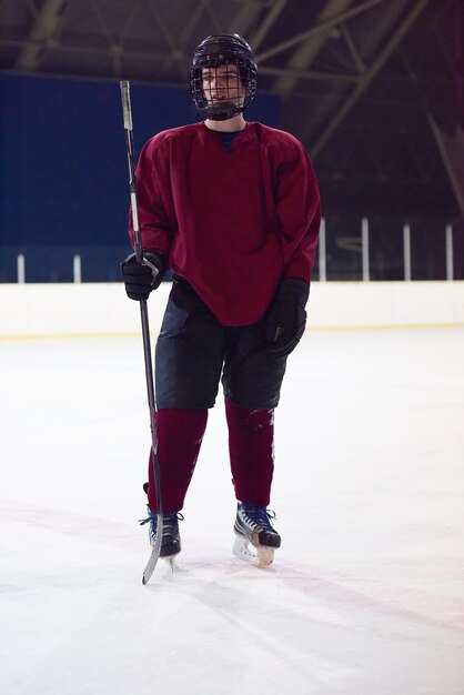 Portrait de jeune joueur de hockey sur glace sur la formation en fond noir