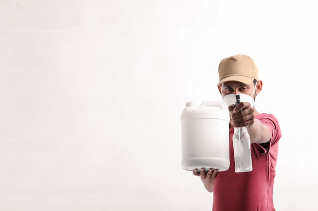 Portrait d'un jeune livreur heureux excité en casquette debout sur fond blanc et tenant la bouteille à la main.