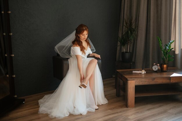 Portrait d'une jeune mariée aux cheveux rouges dans une robe de mariée blanche