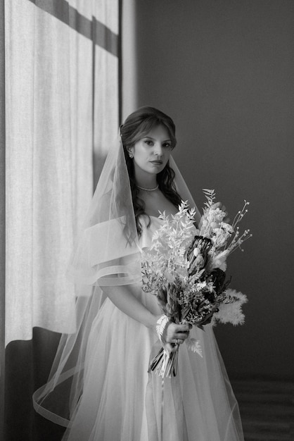 Portrait d'une jeune mariée aux cheveux rouges dans une robe de mariée blanche