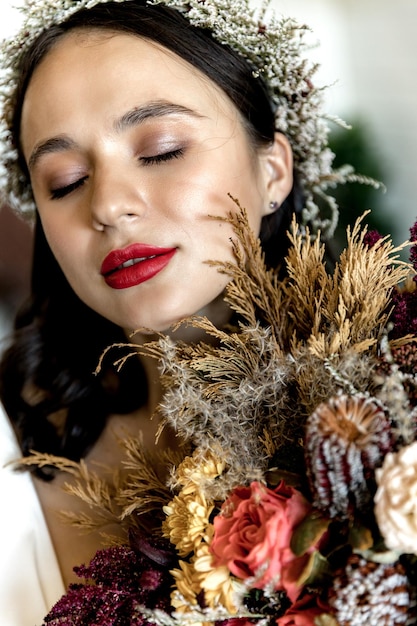 Portrait d'une jeune mariée avec une couronne sur la tête et un bouquet dans les mains photo de haute qualité