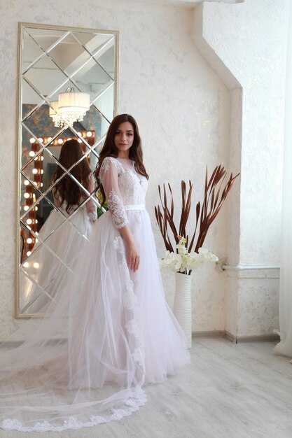 Portrait d'une jeune mariée debout contre le mur à la maison