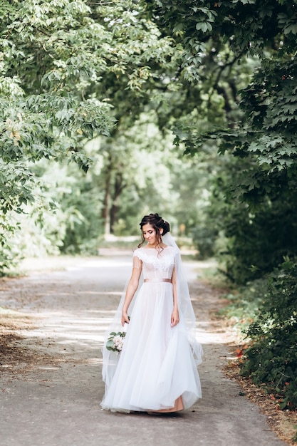 Portrait d'une jeune mariée posant dans la nature