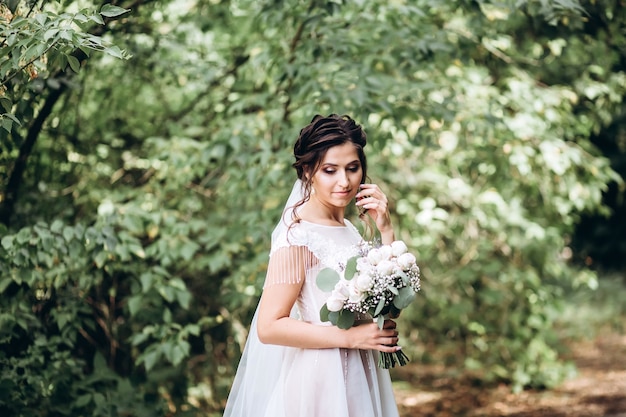 Portrait d'une jeune mariée posant dans la nature