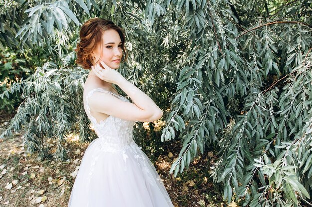 Portrait d'une jeune mariée posant dans la nature