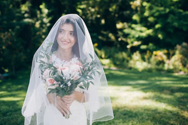 Portrait d'une jeune mariée posant dans la nature