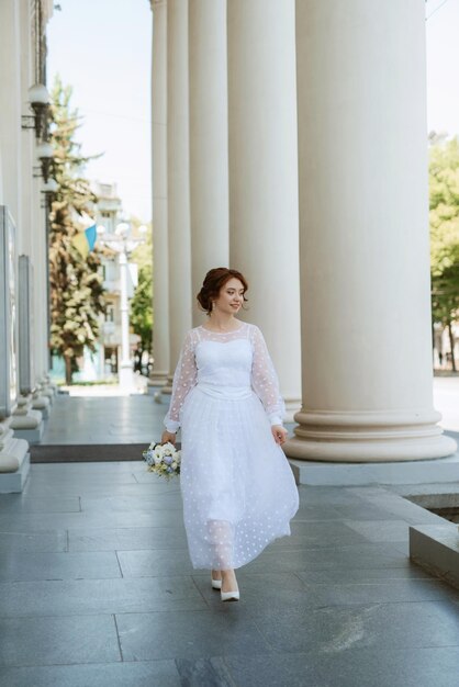 Portrait d'une jeune mariée en robe légère en milieu urbain