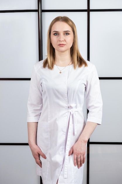 Portrait d'un jeune médecin blond en uniforme blanc