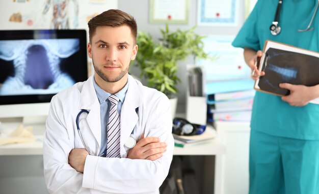 Portrait d'un jeune médecin dans une clinique avec un assistant