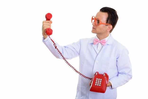 Portrait de jeune médecin fou à l'aide de vieux téléphone