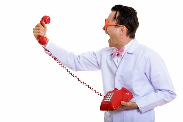 Portrait de jeune médecin fou à l'aide de vieux téléphone