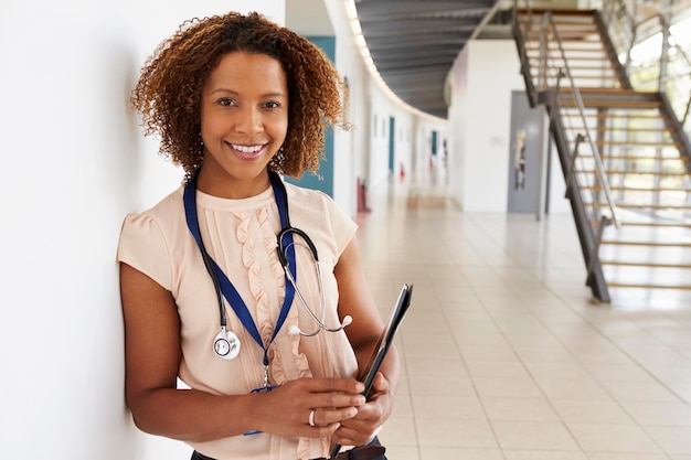 Portrait de jeune médecin avec stéthoscope regardant la caméra