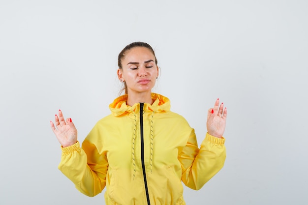 Portrait de jeune méditant en veste jaune et à la vue de face détendue