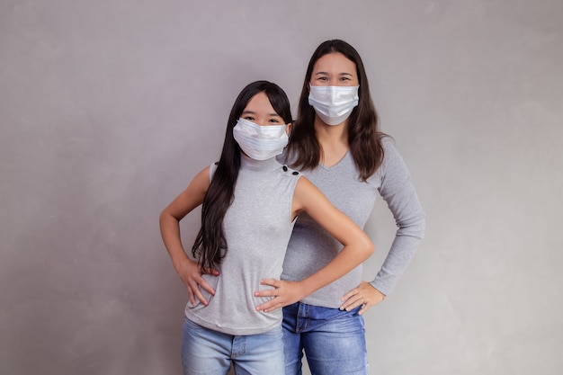 Portrait de jeune mère asiatique avec sa fille enfant portant un masque. mère et fille portant un masque pour protéger covid 19, quarantaine. Restez à la maison concept.