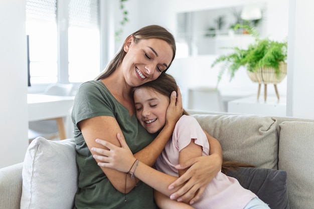 Portrait d'une jeune mère heureuse qui joue au câlin et au câlin montrent l'amour une petite fille d'âge préscolaire mignonne se relaxant dans le salon, une mère souriante et une petite fille se reposent profiter d'un week-end en famille à la maison ensemble