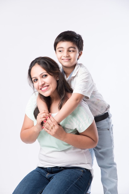 Portrait de jeune mère indienne et fils sur fond blanc, regardant la caméra