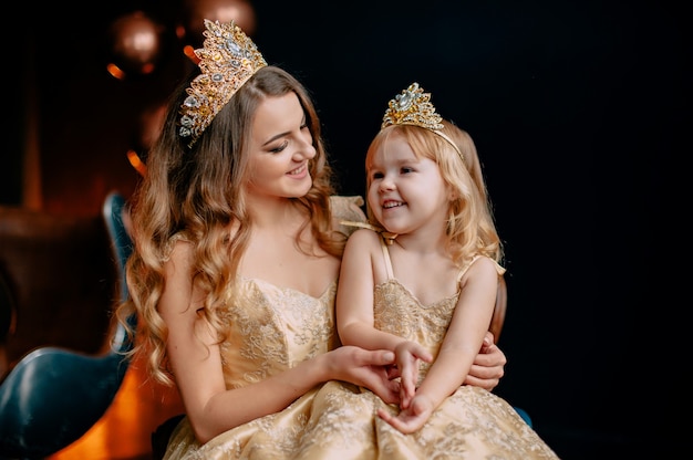 Portrait de jeune mère et petite fille en robes luxueuses