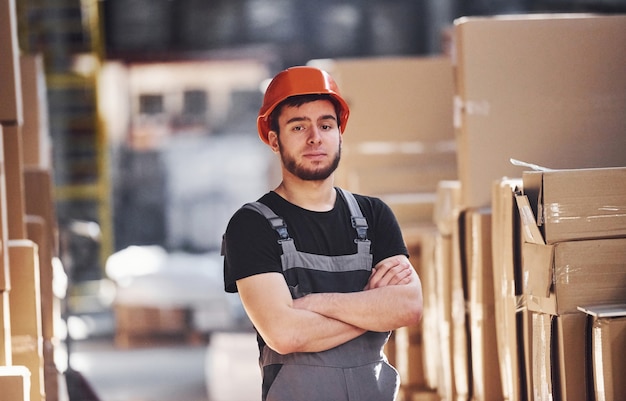 Portrait de jeune ouvrier de stockage dans l'entrepôt en uniforme et casque.