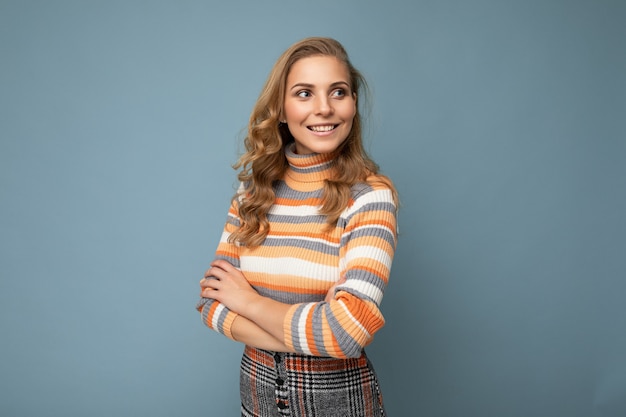 Portrait de jeune séduisante séduisante femme blonde souriante avec des cheveux ondulés portant des rayures