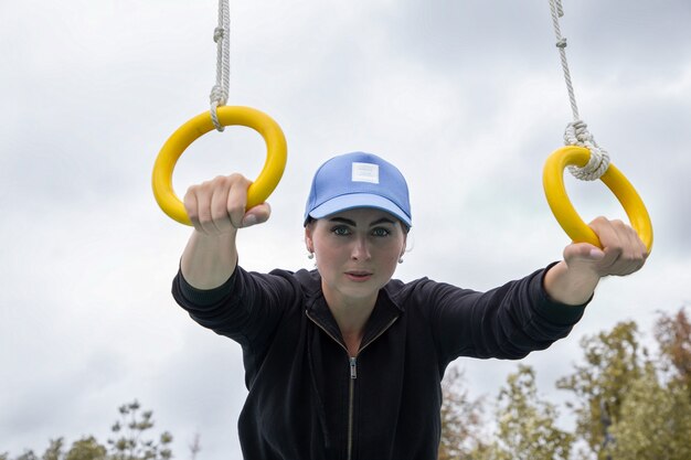 Portrait d'une jeune sportive avec des anneaux de gymnastique