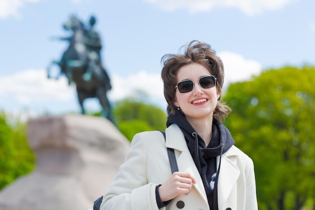 Portrait jeune touriste européen en lunettes de soleil portant un manteau blanc et noir