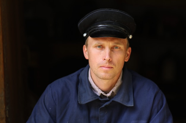 Photo portrait d'un jeune travailleur dans un vieil uniforme