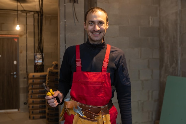 Portrait d'un jeune travailleur joyeux posant en regardant la caméra et souriant en appréciant le travail.