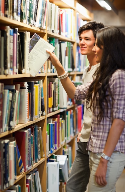 Portrait de jeunes étudiants en choisissant un livre