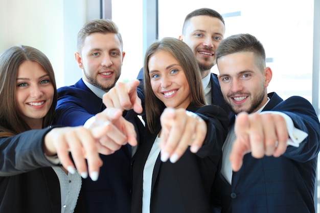 Portrait de jeunes gens d'affaires excités vous montrant du doigt