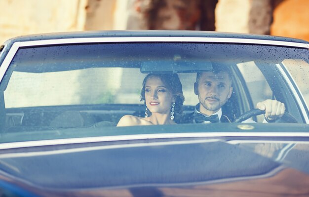 Portrait de jeunes mariés dans la voiture