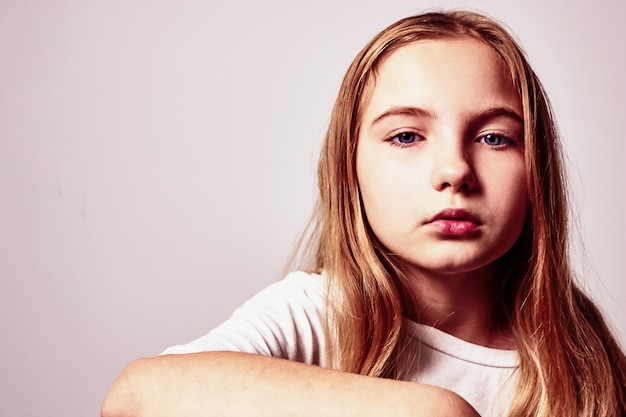 Portrait d'une jolie adolescente pensive aux cheveux longs.