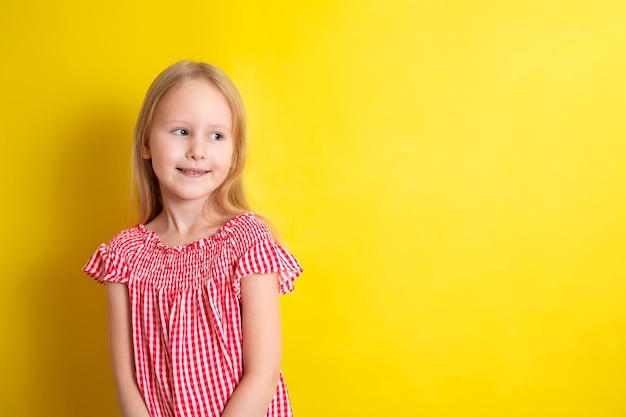 Portrait d'une jolie belle fille blonde souriante sur fond jaune Espace pour le texte Photo de haute qualité