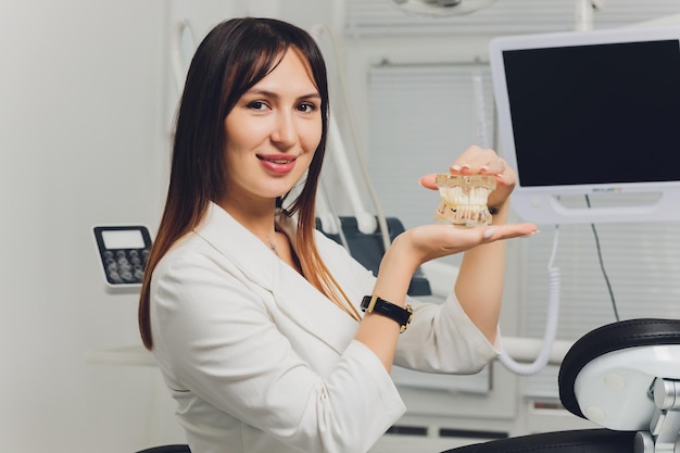 Portrait d'une jolie dentiste souriante avec les mains jointes