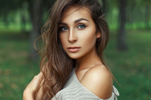 Portrait d'une jolie femme aux yeux bleus incroyables avec la coiffure dans le parc.