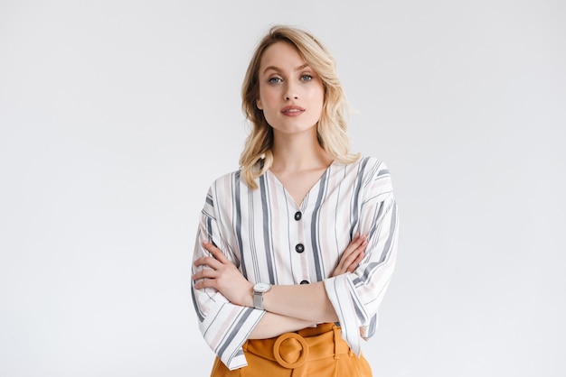 Portrait de jolie femme blonde portant des vêtements décontractés avec les bras croisés isolé sur mur blanc