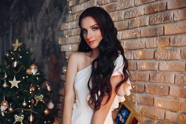 Portrait de jolie femme caucasienne en longue robe blanche