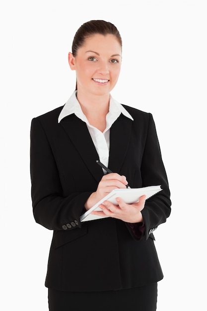 Portrait d&#39;une jolie femme en costume d&#39;écriture sur un cahier