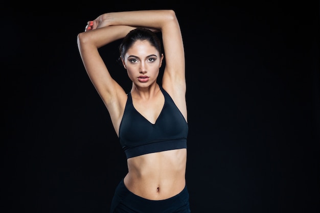 Portrait d'une jolie femme fitness posant sur fond noir