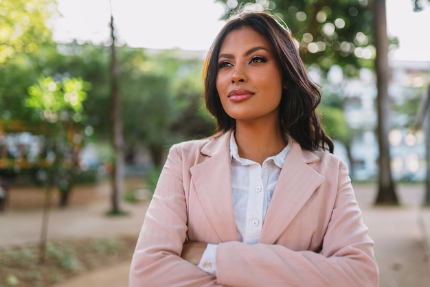 Portrait d'une jolie femme latine marchant dans le parc à l'automne par une journée ensoleillée et souriante