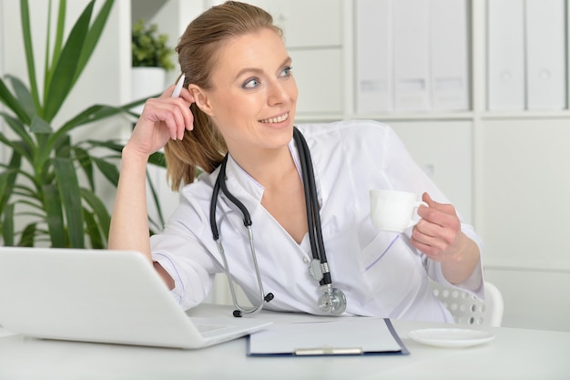 Portrait de jolie femme médecin avec ordinateur portable