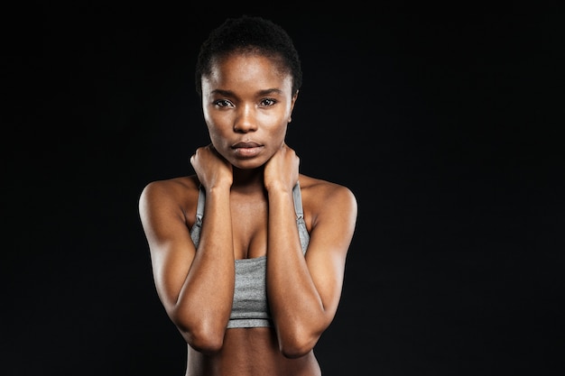 Portrait d'une jolie femme à la peau fraîche isolée sur un mur noir